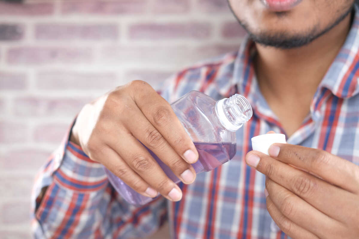 mouthwash liquid flowing into a cap , close up