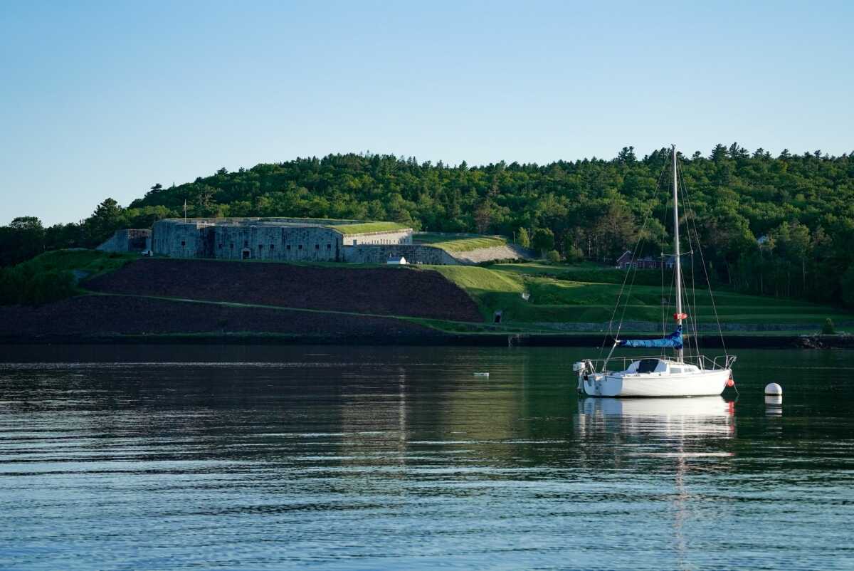 A boat sailing in Penobscot River in front of Fort Knox State Park, Prospect, Maine